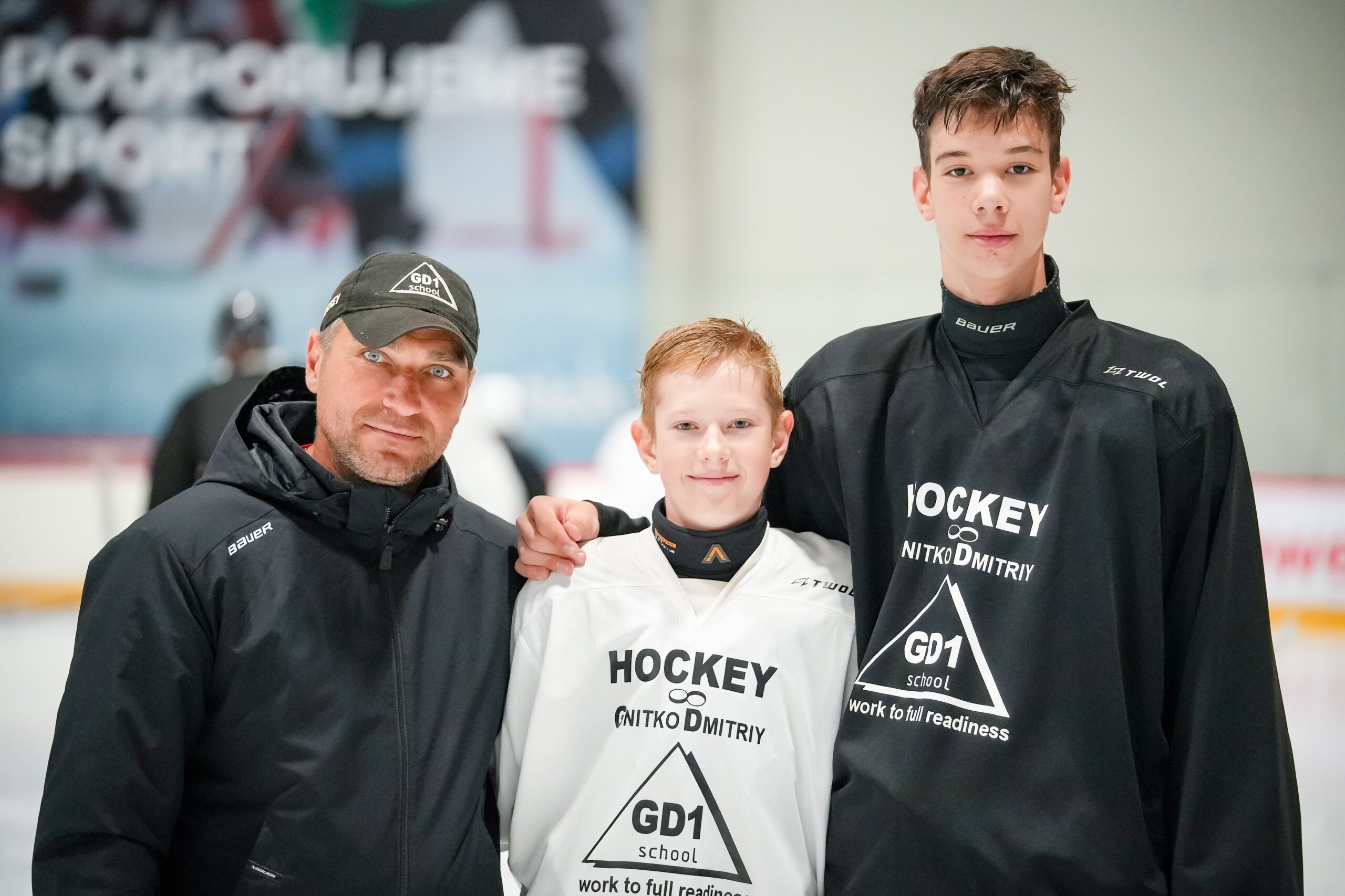 Coach Dmitriy Gnitko with two hockey players