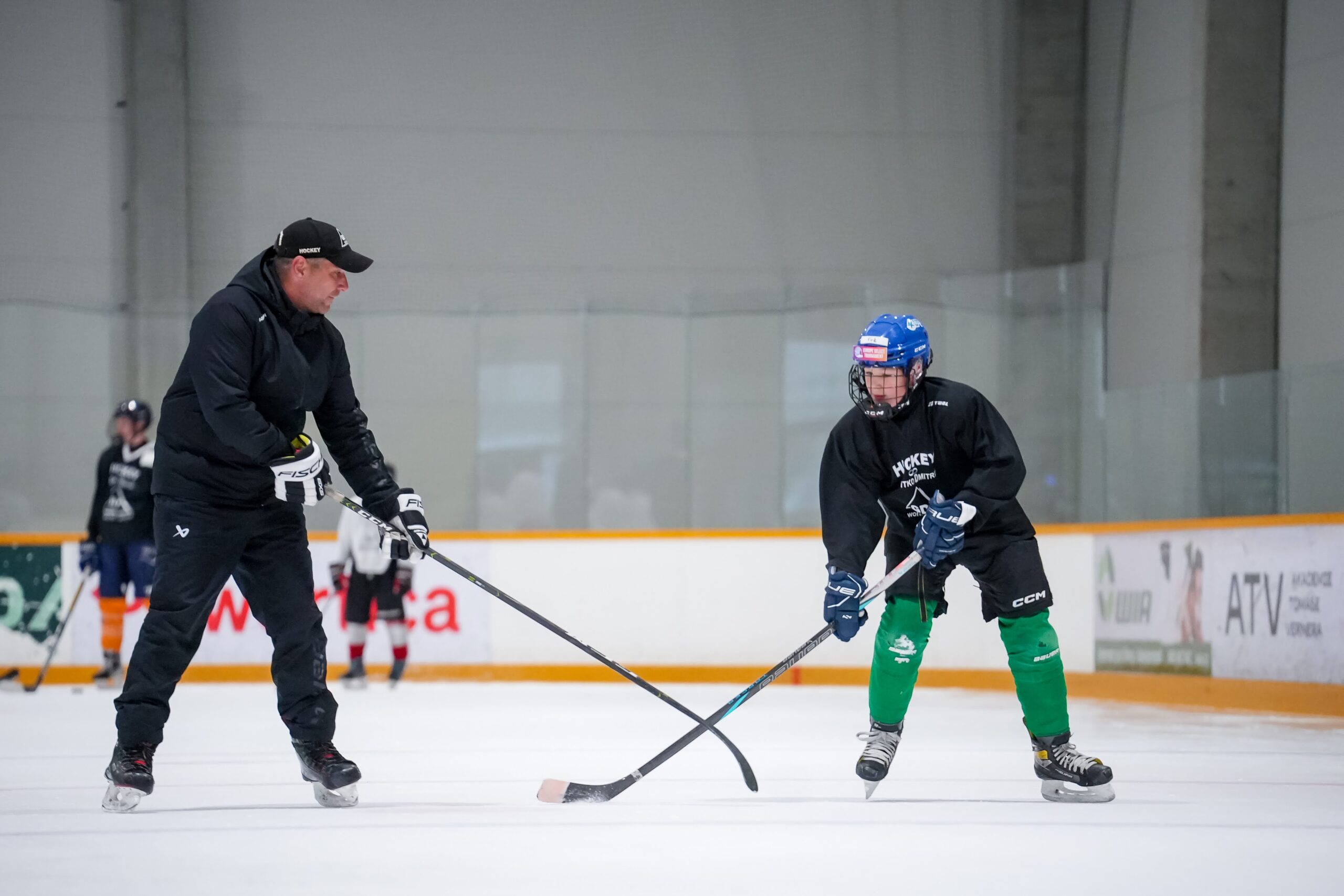 A coach demonstrating a hockey drill to a player