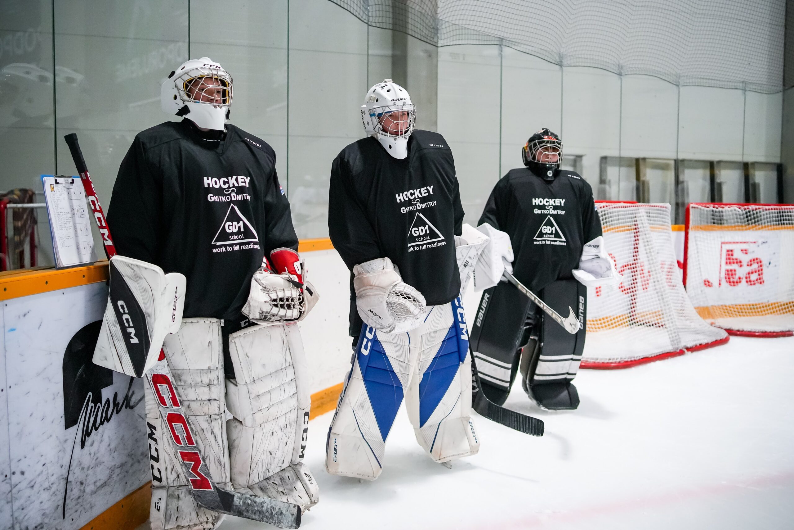 Three goalkeepers standing by the net