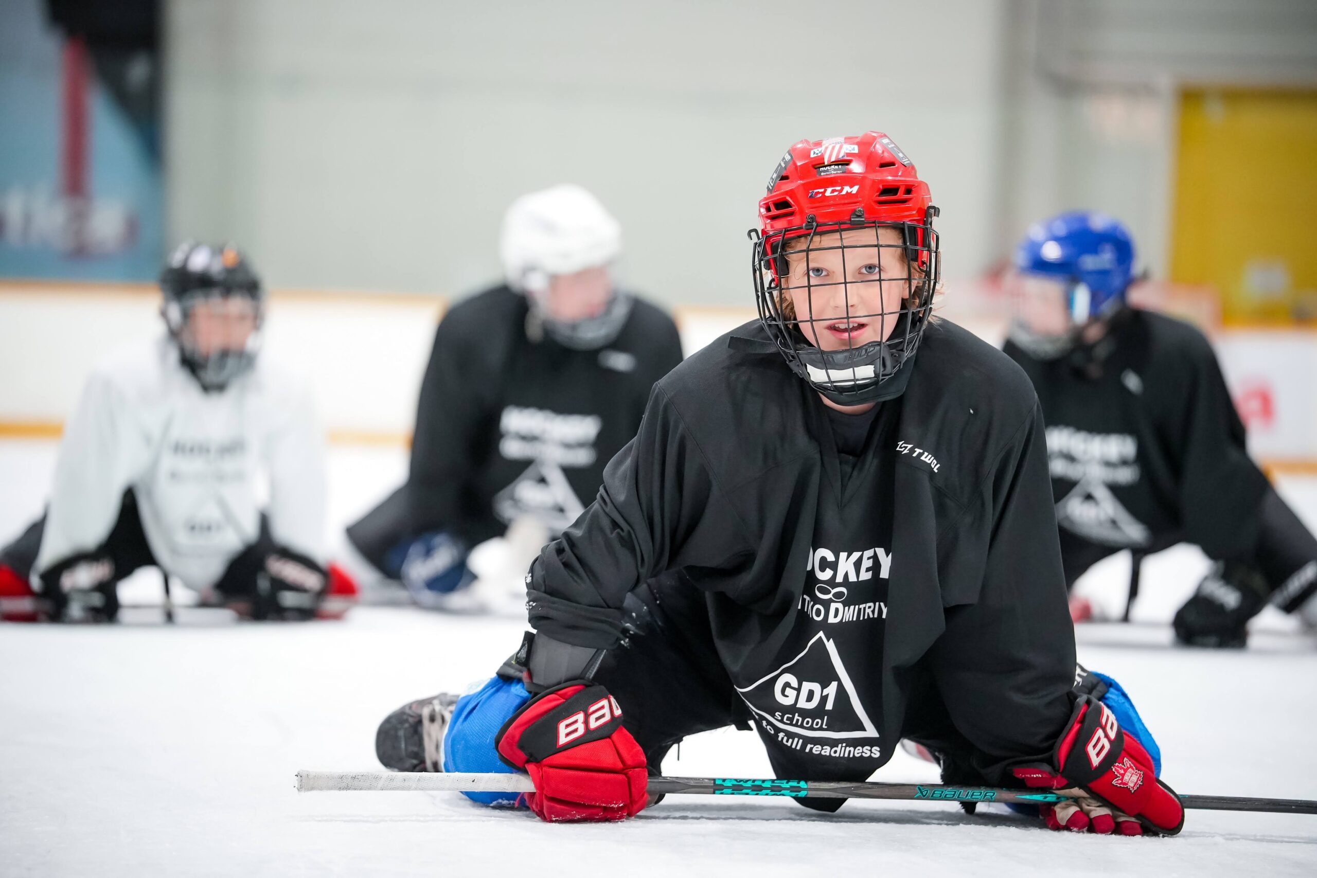 A young player resting on the ice during practice