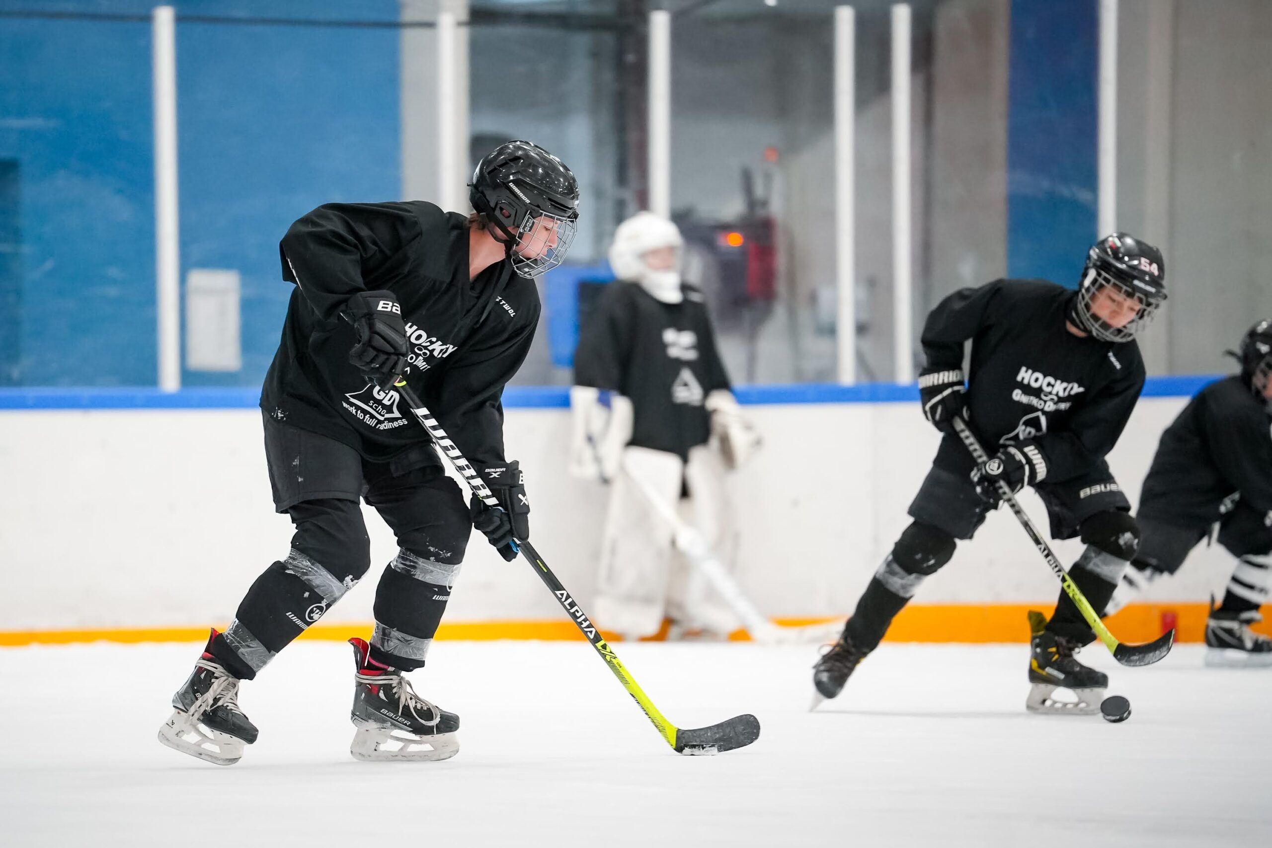 Players practicing puck control on the ice