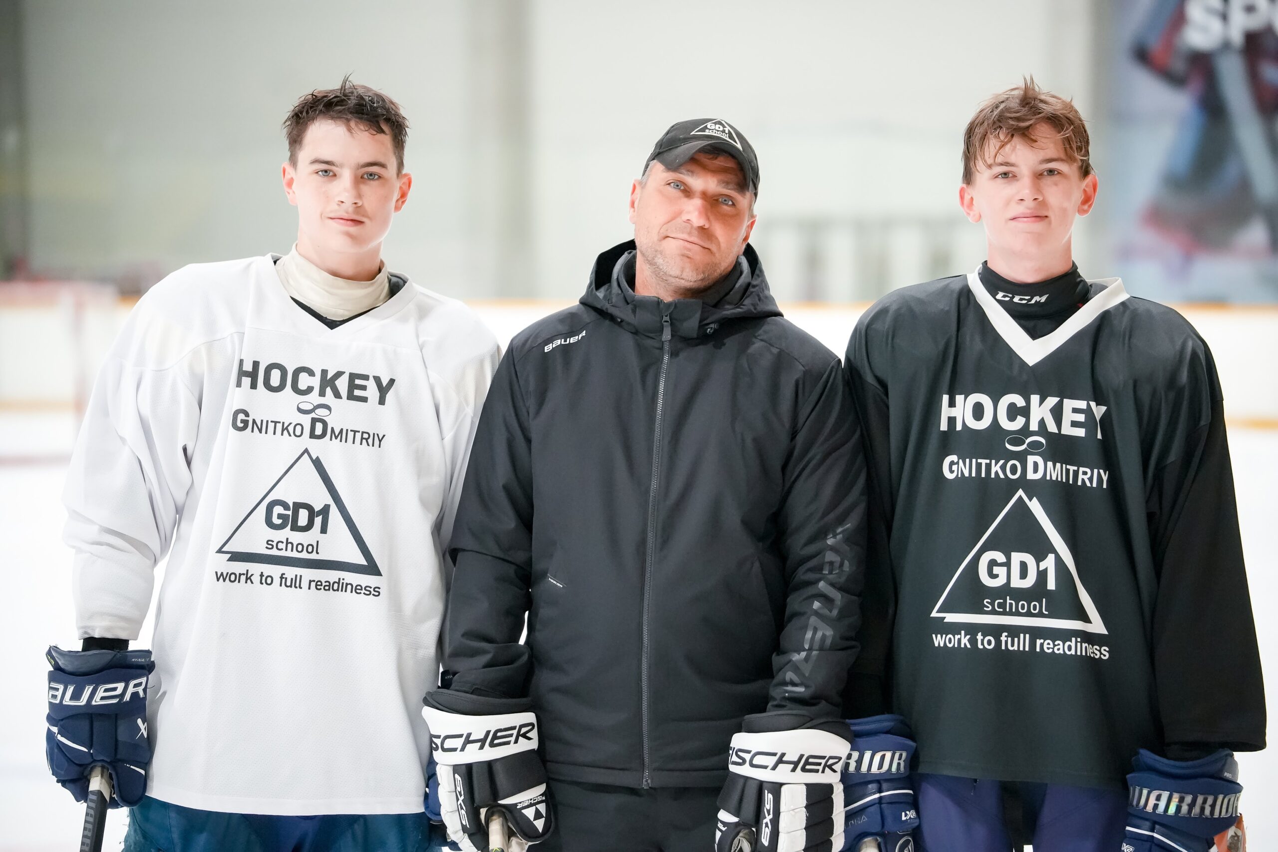 GD1 coach standing with two players at the rink
